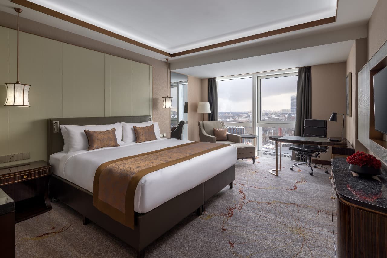 Premium room with a large bed, seating area and panoramic windows